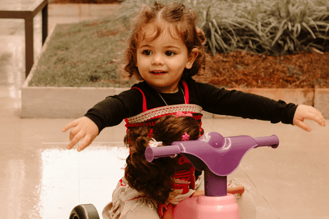 maria eduarda abrindo os bracinhos, brincando em cima da motoca'