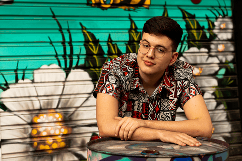 nathan apoiado em um barril, na frente de uma garagem'