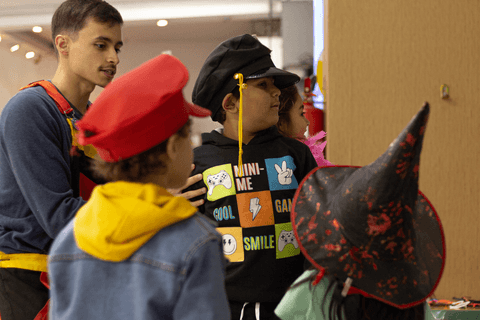 pedro e seus amigos fantasiados esperando para rodar no brinquedo enquanto grava uns vídeos e umas fotos'