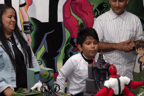 pedro ao lado dos seus pais apagando a vela após o parabéns'