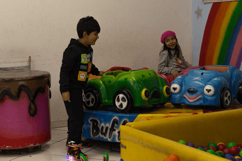 pedro brincando com uma de suas amigas nos carrinhos de bate bate'