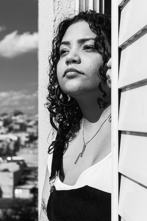 suelen com o rosto para fora da sua janela, tomando sol, foto em preto e branco'