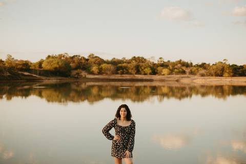 ensaio feminino externo a beira do lago com roupa preta e branca e chapeu marron estilo boho, menina cacheada. fotos no por do sol, '