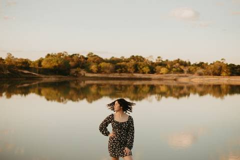 ensaio feminino externo a beira do lago com roupa preta e branca e chapeu marron estilo boho, menina cacheada. fotos no por do sol, '