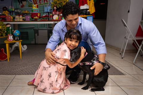 Aniversário Infantil no play, aniversariante com o pai e com o cachorro que desceu para a festa na hora do parabéns'