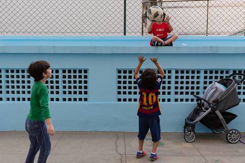 Aniversário no play, crianças jogando bola, uma delas no alto'