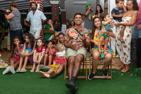 Aniversário Infantil, pais e convidados assistindo a retrospectiva de um ano da aniversariante na Casa de Festa Alegria de Viver, em Jacarepaguá'