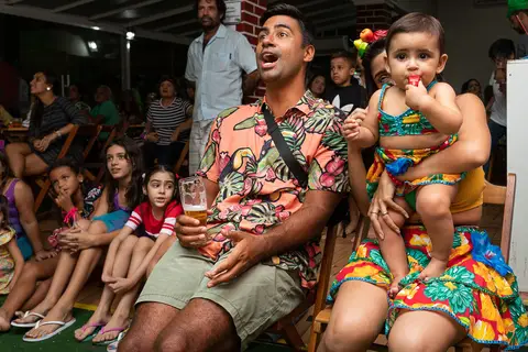 Aniversário Infantil, pais e convidados assistindo a retrospectiva de um ano da aniversariante na Casa de Festa Alegria de Viver, em Jacarepaguá'