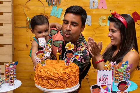 Aniversário Infantil, hora do parabéns, pai ajudando a criança a apagar a vela do bolo na Casa de Festa Alegria de Viver'