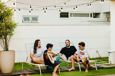 menino-tocando-violão-em-famíla'