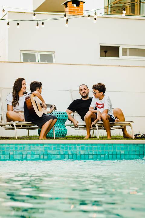 menino-tocando-violão-em-famíla'