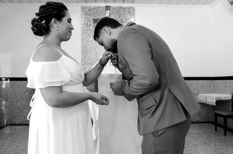 Casamento Religioso durante o dia, Noivo beija a aliança na mão da noiva, Noiva recebendo beijo do noivo, Noivos diante do Altar'