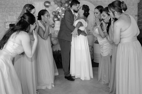 Casamento Religioso durante o dia, Noiva mostra alianças para as Madrinhas, Madrinhas contemplam beijo e aliança dos noivos, Esposos se beijam'