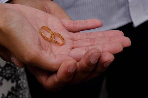 aliança na mão da noiva sustentada pelo noivp'