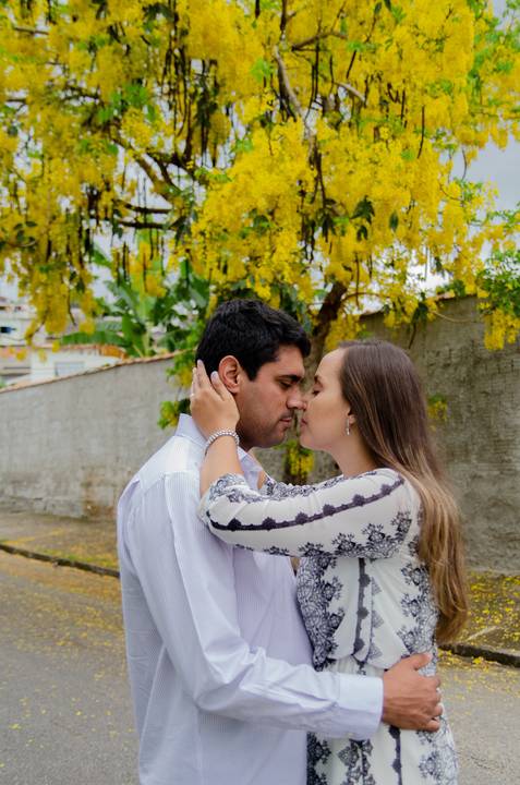 sob uma árvore florida de amarelo, novo casal, marido e esposa de beijam'