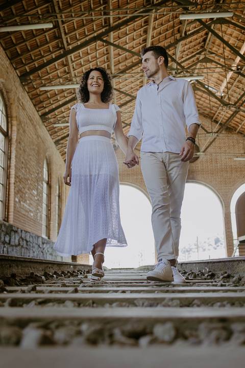 perspectiva baixa do casal caminhando nos trilhos do trem'