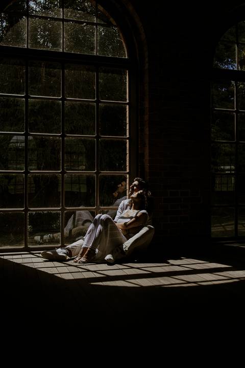 close do casal no sol que entra pela janela na estação de trem de Paranapiacaba'