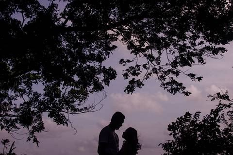 casal um de frente para o outro na sobra das árvores'