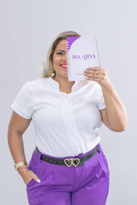 foto de mulher loira empreendedora cobrindo o rosto com agenda'