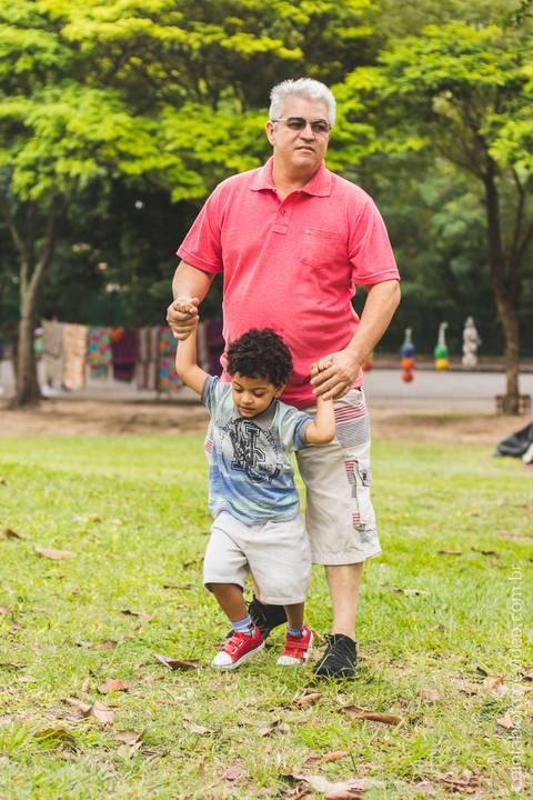 pai brinca com filho na grama '