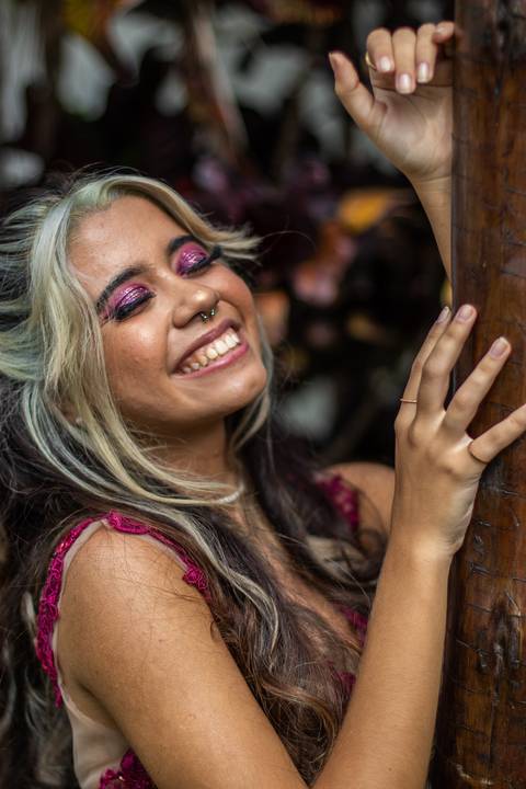 Debutante de 15 anos sorri para câmera no jardim'