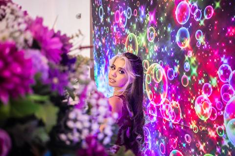 Debutante de 15 anos posa para foto em decoração de festa'