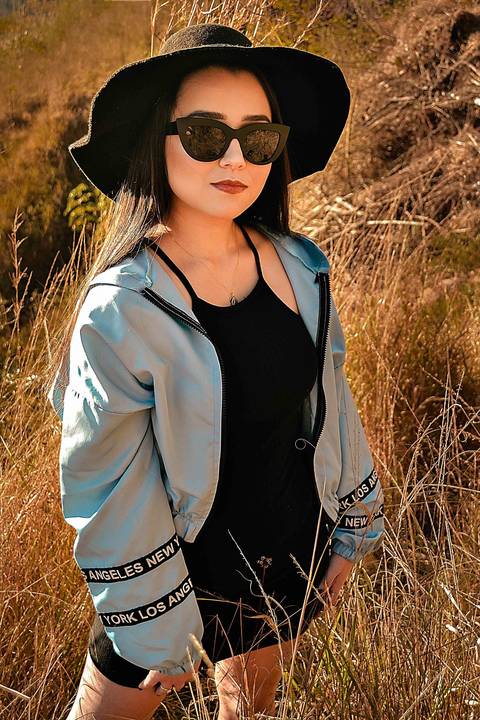 Foto tirada ao por do sol com a modelo de frente com chapéu '