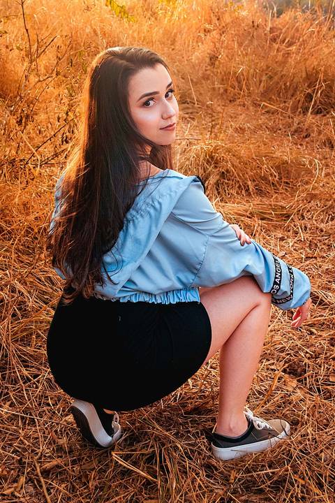 Foto tirada ao por do sol com a modelo de costas e abaixada'