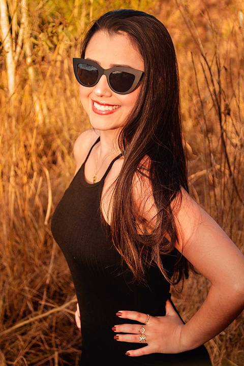 Foto tirada ao por do sol com a modelo de frente sorrindo '