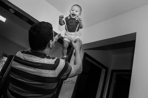 Pai jogando filho para cima'