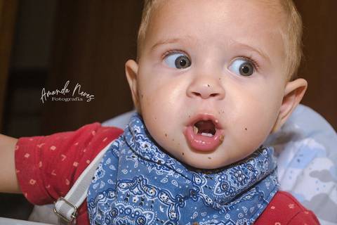 Criança fazendo careta enquanto se alimenta'