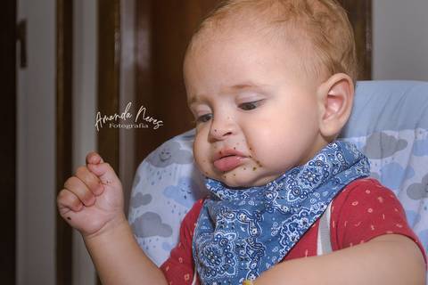 Criança fazendo careta enquanto se alimenta'