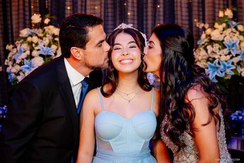 pais beijando o rosto da debutante sophia durante sua festa de 15 anos'