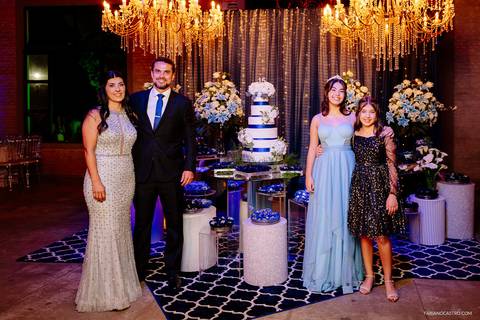 família da debutante sophia posando para o retrato oficial em frente a mesa do bolo'