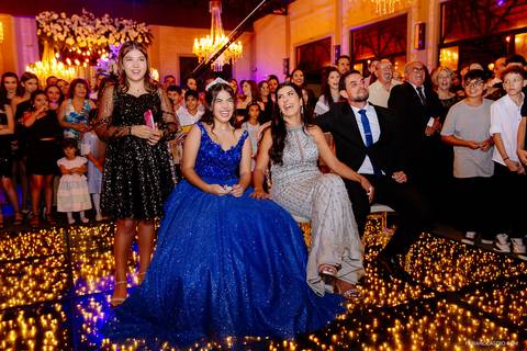 família da debutante sorrindo feliz assistindo no telão as fotos e vídeos da vida da sophia'