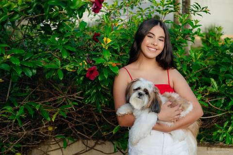 Sophia posando para foto com seu cachorrinho durante seu ensaio de 15 anos'