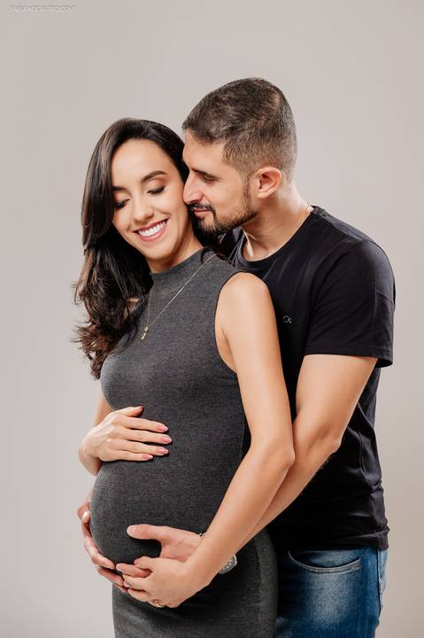Fotografia de gravida com marido em estúdio fotográfico'