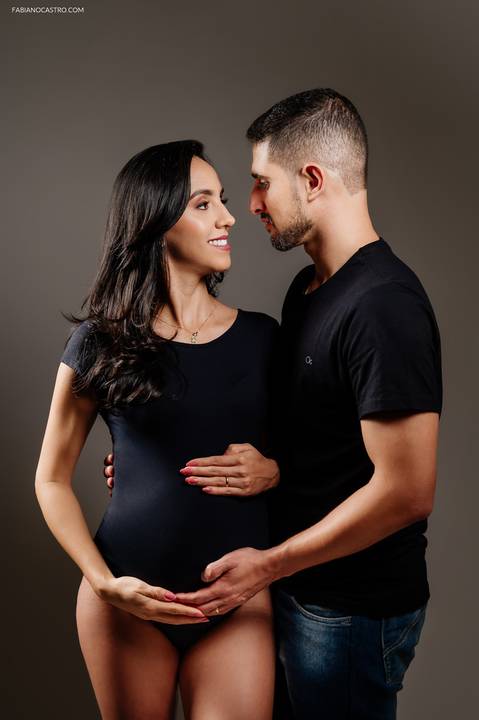 Fotografia de grávida com marido em estúdio fotográfico'