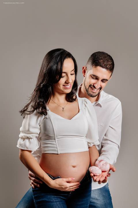 Fotografia de gestante com marido em estúdio fotográfico'