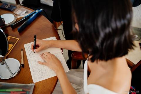 noiva escrevendo os votos durante o making of
'