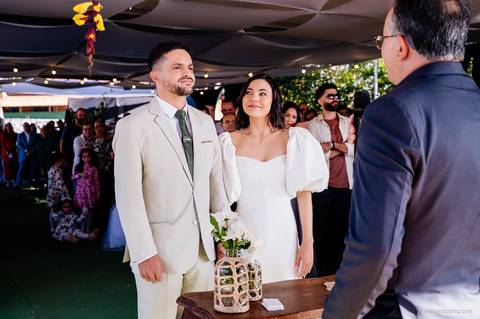 noiva emocionada olha para o noivo durante celebração do seu casamento'