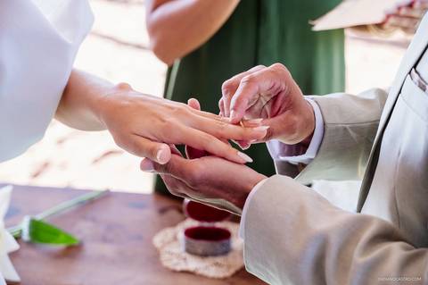 detalhe em close do noivo colocando a aliança na noiva'