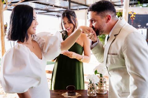 noivo beija a mão da noiva após colocar a aliança'