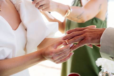 detalhe em close da noiva colocando a aliança na noivo'