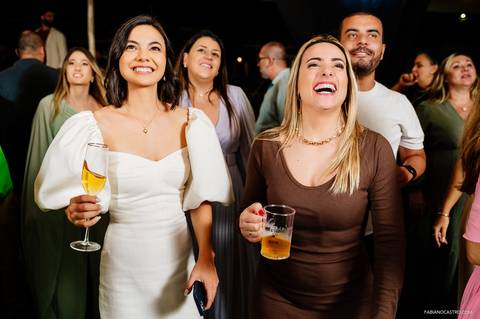 noiva feliz vendo noivo cantando no palco durante casamento em fama-mg'