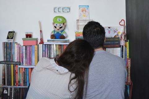 Casal de costas olhando pra os livros'