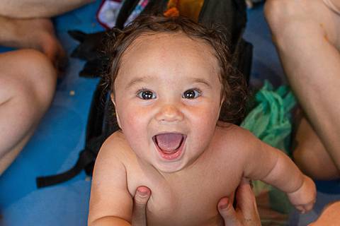 Criança olhando e sorrindo para a câmera'