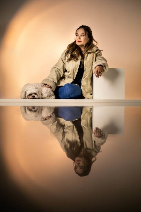 Mulher sentada ao lado de um cachorrinho'