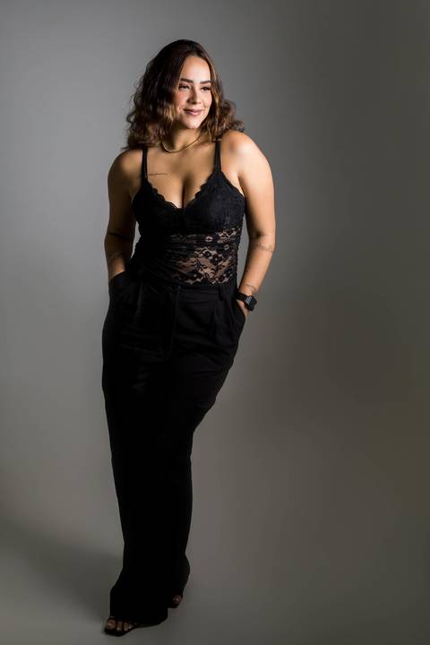 mulher vestida toda de preta com as mãos no bolso'