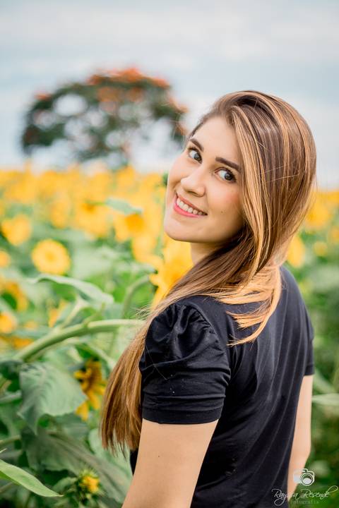 foto de perfil de uma mulher no campo de girassóis da alta genetics do brasil'